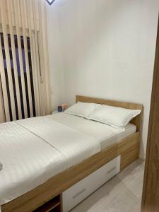 een slaapkamer met een bed met witte lakens en een raam bij Apartment DUNJA Laktasi in Laktaši