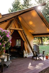 een tent met twee stoelen op een houten terras bij Duck Pond Oasis - Glamping in The Dalles
