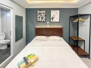 een slaapkamer met een groot bed en een toilet bij Torisan Hotel in Stasiun Tawang
