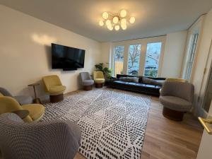 un soggiorno con divano, sedie e TV di Assemble Boise a Boise