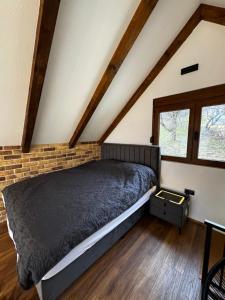 een bed in een kamer met een bakstenen muur bij Monte Rustic Chalets in Mojkovac +5 foto's