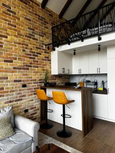 eine Küche mit weißen Schränken und einer Ziegelwand in der Unterkunft Monte Rustic Chalets in Mojkovac