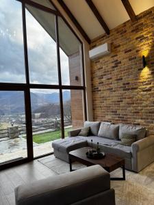 een woonkamer met een bank en een groot raam bij Monte Rustic Chalets in Mojkovac