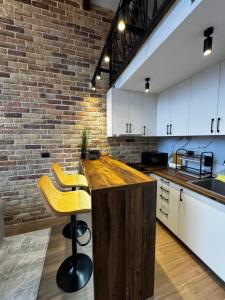 eine Küche mit einer Holztheke und einer Ziegelwand in der Unterkunft Monte Rustic Chalets in Mojkovac