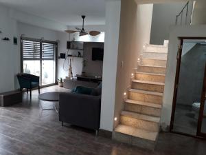 a living room with a staircase and a couch at CASA CON PILETA EN EL CENTRO de CORRIENTES in Corrientes +6 photos