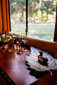 een houten tafel met glazen en een vogel op een bord bij Duck Pond Oasis - Glamping in The Dalles
