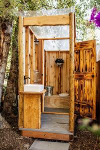 een houten badkamer met een wastafel en een toilet bij Duck Pond Oasis - Glamping in The Dalles