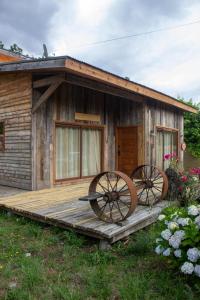 a wooden cabin with two wagon wheels on a deck at Hostal Celta in Pucón