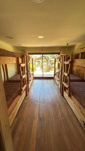 a room with four bunk beds and wooden floors at Hostal Celta in Pucón