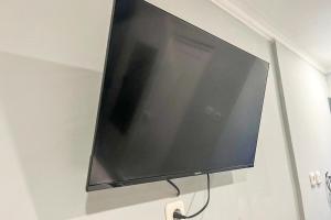 een flatscreen-tv die aan de muur hangt bij Torisan Hotel in Stasiun Tawang