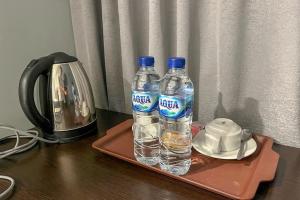 twee flessen water op een dienblad op een tafel bij Torisan Hotel in Stasiun Tawang