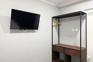 een flatscreen-tv hangend aan een muur in een badkamer bij Torisan Hotel in Stasiun Tawang +7 foto's