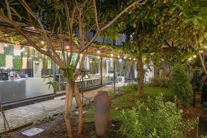 een gebouw met bomen en een vaas in een tuin bij Torisan Hotel in Stasiun Tawang