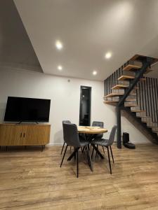 ein Esszimmer mit Tisch und Stühlen und einer Treppe in der Unterkunft Stodoła Parysa 