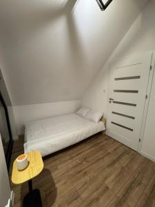 ein kleines Schlafzimmer mit einem Bett und einem Tisch in der Unterkunft Stodoła Parysa 