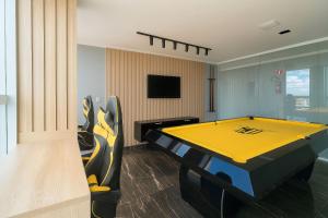 a room with a yellow ping pong table in it at Apto elegante no Catolé 28 in Campina Grande