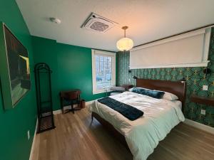 una camera da letto con un letto con una parete verde di Assemble Boise a Boise