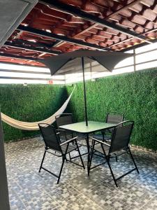 a table and chairs with an umbrella and a hammock at Departamento Ecoface Vallarta in Puerto Vallarta