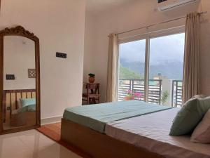 een slaapkamer met een bed, een spiegel en een raam bij Prithvi Hotel - Aesthetic Quite Rooms In Upper Tapovan with free airport pickup for 7 or more nights booking in Rishīkesh +17 foto's