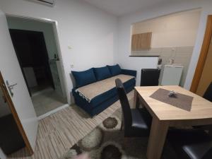 a small room with a blue bed and a table at Guest House Nana in Mostar