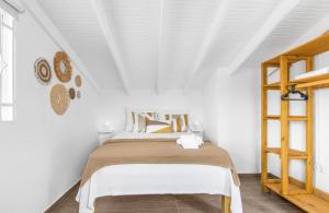 a white bedroom with a bed and a wooden ladder at Something Els in Willemstad