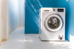 a washing machine in a room with a blue wall at Something Els in Willemstad