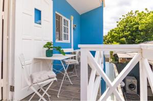 a blue and white house with a table and chairs on a balcony at Something Els in Willemstad