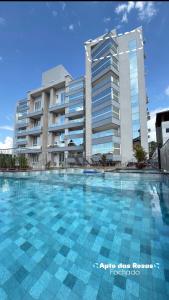 een groot zwembad voor een gebouw bij Apto das Rosas - 3 Quartos, Apto todo climatizado, à poucos metros do Parque Termal! in Piratuba