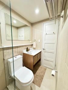 ein Badezimmer mit Toilette und Waschbecken in der Unterkunft 1413 Home Suites Arezzo Place Davao in Davao City + 8 Fotos