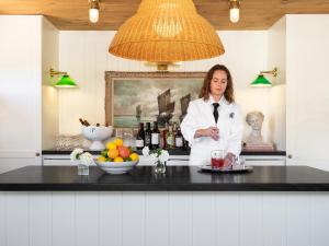 une femme en blouse blanche de laboratoire se tenant derrière un comptoir dans l'établissement Le Petit Pali St Helena, à St. Helena