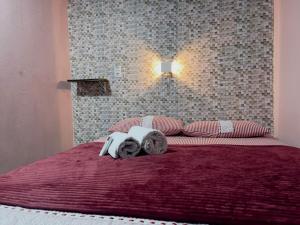 a bedroom with a red bed with towels on it at Pousada - Casa dos Paiva in Barreirinhas +29 photos
