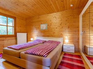 een slaapkamer met een bed in een houten kamer bij Karawankenpanorama in Liebenfels