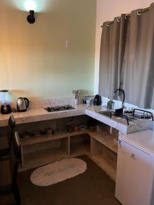 een keuken met een aanrecht met een wastafel en een koelkast bij Chalé vista da vila in Sao Jorge +13 foto's