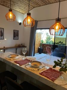 een eettafel met wijnglazen en lampen bij Chalé vista da vila in Sao Jorge