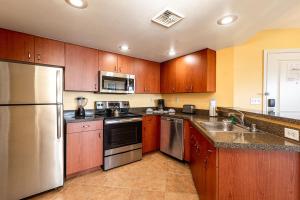 a kitchen with wooden cabinets and stainless steel appliances at DeeDee Al Resort in Las Vegas +3 photos