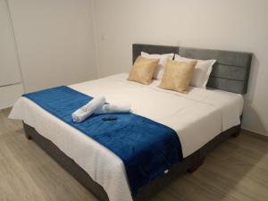 a bedroom with a bed with two towels on it at Cabañas hotel COLONIA SAN MIGUEL in Paipa
