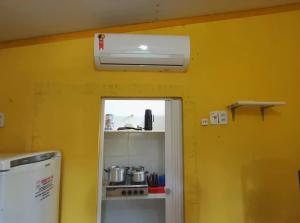 a kitchen with a white heater and a yellow wall at casa n 3 jeri in Jericoacoara
