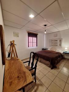 een slaapkamer met een bed en een houten bank erin bij Urban Cabin with a Rustic Touch in Concepción de Ataco