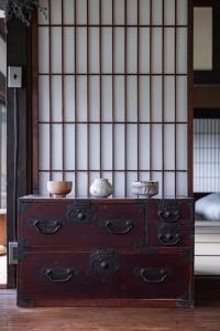 una vecchia cassettiera con delle ciotole sopra di ëighten Private Guesthouse Yoga Retreat 1日1組限定古民家宿エイテン a Hokuto