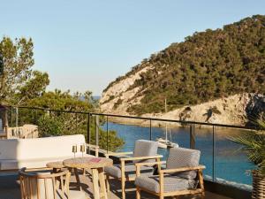 patio con sedie, tavolo e vista sull'acqua di Mondrian Ibiza a Cala Llonga