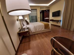 Postel nebo postele na pokoji v ubytování KAY-EM Spectra Hotel