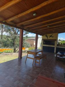 een houten patio met een tafel en een open haard bij Casa en Cabalango in Cavalango