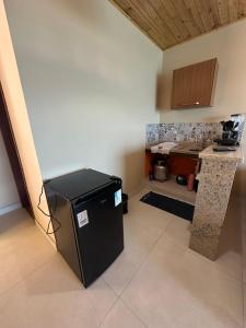 eine Küche mit einem schwarzen Kühlschrank und einer Theke in der Unterkunft Araçatiba Praia Flats in Angra dos Reis