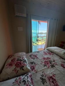 ein Schlafzimmer mit einem Bett und Meerblick in der Unterkunft Araçatiba Praia Flats in Angra dos Reis