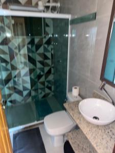 ein Badezimmer mit Waschbecken, Toilette und Dusche in der Unterkunft Araçatiba Praia Flats in Angra dos Reis