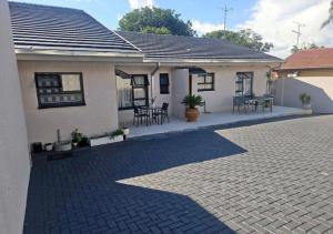 una casa con patio arredato con tavolo e sedie di Peite Grounds Inn a Polokwane