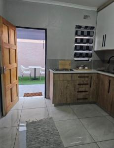 una cucina con porta che si apre su un patio con tavolo di Peite Grounds Inn a Polokwane
