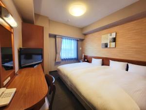 a hotel room with two beds and a desk with a computer at Hotel Route-Inn Fujieda-Eki Kita in Fujieda +34 photos