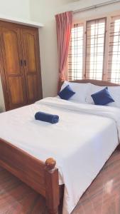 un grande letto con un telecomando blu sopra di Indeevaram a Cochin