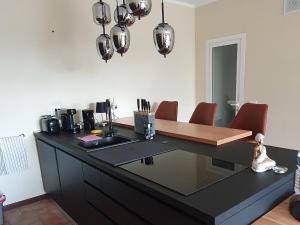 a kitchen with a black counter with red chairs at Poolside Apartment in Italian Villa in San Lorenzo al Mare